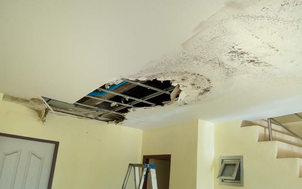 Side view of a ceiling with severe water damage and exposed home structure