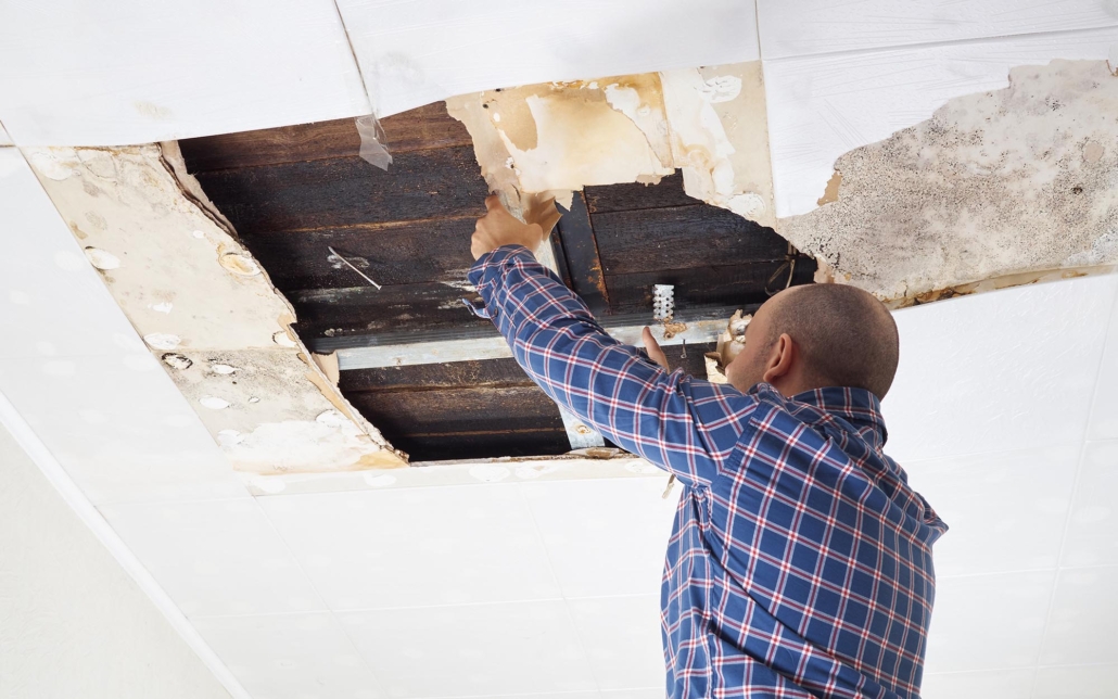 Worker inspecting roof damage