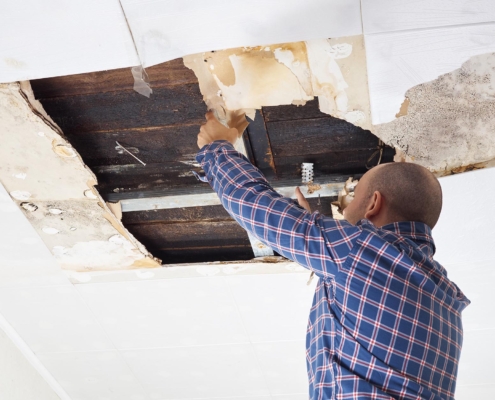 Worker inspecting roof damage