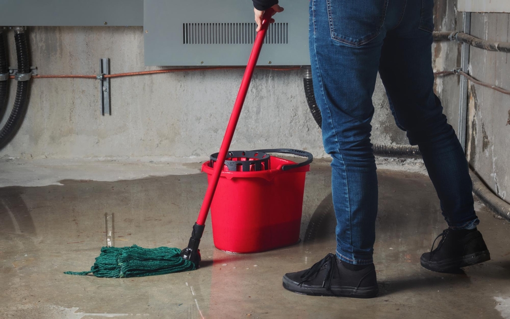 homeowner cleaning up water from basement