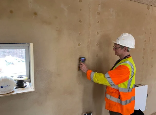 Water Damage Cleanup Services: What's Included And How To Know If You're Getting It All 3 water damage cleanup services technician using moisture meter to detect hidden water in walls
