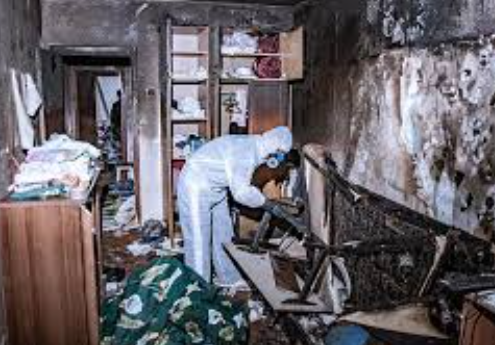 Fire Damage Restoration: A Step-by-Step Guide to Recovering After a House Fire 19 Person cleaning a damaged room